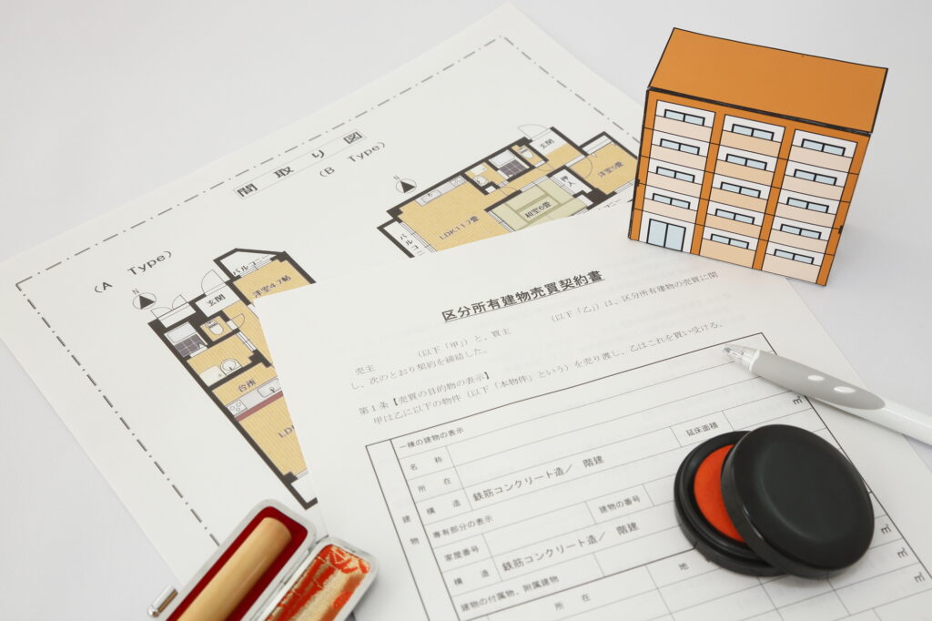 マンションの図面、区分所有建物売買契約書、印鑑、朱肉、ボールペン、マンションの模型